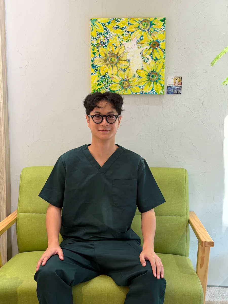 穿著深綠色醫療服的專心動物醫院團隊成員坐在綠色沙發上